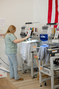 Embroidery machine in progress stitching on fabric in a bright workspace. Photograph by Yucaipa branding photographer Kaitlyn Dawn Photography.