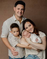 Parents holding their newborn baby during a studio family portrait session with newborn photographer Kaitlyn Dawn Photography.