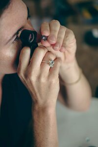 Custom Jewelry Designer Looking at Gemstone with Loupe