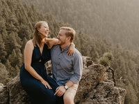 couple laughing on top of a mountain