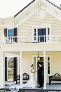 Bride and groom sharing a first look on the front porch of Bradshaw Duncan House, a classic wedding venue near Louisville.