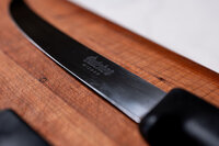 The blade of a knife sitting on a cutting board