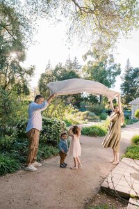 parents playing peekaboo with blanket