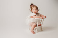 Charleston Cake Smash Photographer- Baby looks into the camera during Milestone Portraits at Holy City Babies Portrait Studio in Charleston, SC.