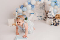 Baby grins at the camera during her 1st birthday photoshoot at Holy City Babies Portrait Studio in Charleston, SC.