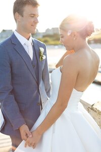 Bride and Groom pose on boardwalk at sunset.