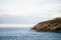 Wide landscape view of the rugged volcanic coastline at Halona Blowhole in Hawaii, captured by destination photographers The Reeses.