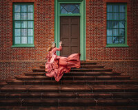 Child in a flowing dusty pink gown twirling on brick steps at a historic home in New Bern NC