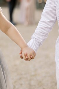 Close-up of the Dilorio family children holding hands during a soft, golden hour outdoor photography session in Las Vegas, capturing a tender sibling moment.