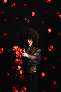 Artist photographed against a dark set with dramatic red lighting