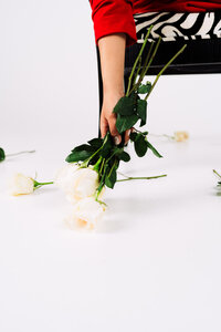 Creative business owner photographed with white roses during a colorful personal brand photoshoot.