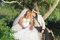 Venice Beach Los Angeles wedding photography of the bride and groom kissing under a tree in the venue garden, captured in true to life color with a romantic fine art look.