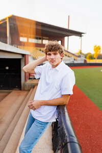 senior boy on the field where he plays baseball in high school