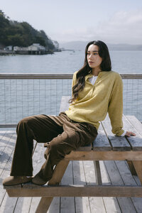 Seasonal lookbook frame: chartreuse cardigan and chocolate corduroy trousers at a weathered picnic table