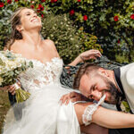 Groom playfully removing bride’s garter during wedding photos at Waterton Park Hotel, Yorkshire, captured by Yorkshire wedding photographer.