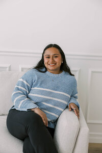 Woman sitting on a loveseat at The Bunny Hive