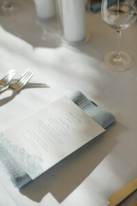 Baby blue wedding menu on blue napkin during Nantucket wedding.