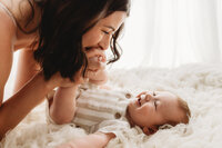 Charleston Mini Sessions - Mother embraces her baby during Mother's Day Mini Session at Holy City Babies in Charleston, SC.