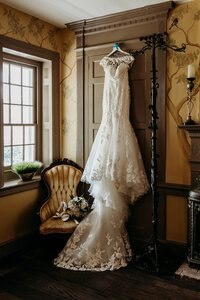 Bridal gown hanging in a historic room at Bradshaw Duncan House, a wedding venue near Louisville Kentucky.
