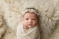 Sweet little girl wrapped in neutral colors for her newborn session in Minnesota.