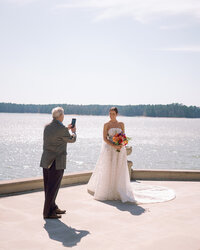 Bride posing by the lake with a colorful bouquet during her Huntsville wedding ceremony.