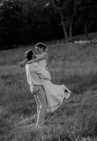 Couple embracing at sunset during a romantic outdoor engagement photography session with golden light and scenic landscape.