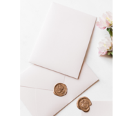 Detail shot of powder pink envelopes and gold wax seals