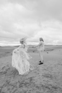 man and woman posing on a windy beach in Utah Sand Dunes Elopement