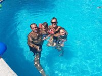 Family in pool smiling