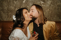 A person kissing their partner on the cheek 