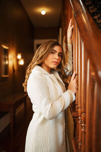 Senior portrait at the Malaga Inn in Mobile, Alabama— closeup holding the rails of the bannister.