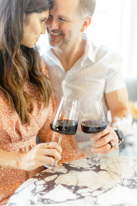 A beautiful photo of the two owners of Sip and Savor playfully posing for their professional headshot/branding session while holding glasses of red wine.