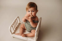 Charleston Baby Milestone Photographer - Baby slobbers on a wooden toy during his Milestone Portrait Session at Holy City Babies Portrait Studio in Charleston, SC.