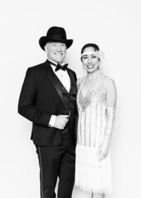 Luxury fine art portrait from Luxe Portraiture LV featuring a couple in glamorous 1920s‑inspired attire captured in timeless black‑and‑white portrait photography that highlights vintage sophistication and style.