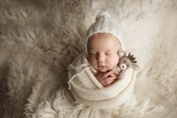 Infant boy wrapped up for his baby photo session in Southern Minnesota.
