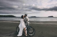 couple eloping in tofino bc at mackenzie beach resort using beach bikes