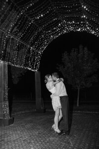 Bride and groom kissing under the fairy light tunnel arch at Petrichor Farm, Gundaroo NSW