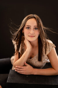 A girl from Oconomowoc High School has her senior portrait taken in our Waukesha Studio gazing straight into the camera.