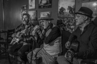 Black and white photo of three people playing music together