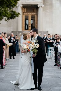 Bride and groom kiss in aisle