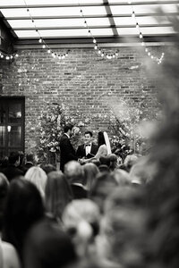 A black and white view of a wedding ceremony at Wythe Hotel, preserving the atmosphere and emotion of an intentional Brooklyn celebration.