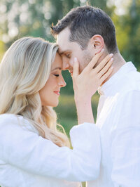 A close-up of a couple embracing during a maternity photo session in Magnuson Park in Seattle