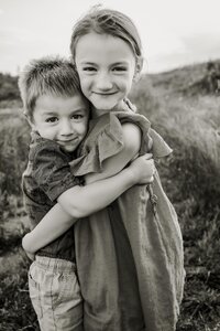 Boy and girl siblings playfully embrace at a session in Arbor Hills in Plano Texas