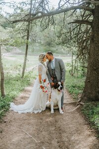 Sacramento Wedding Photographer captures bride and groom holding dog's leash on wedding day