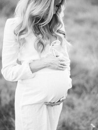 Black and white image of a woman's pregnant belly