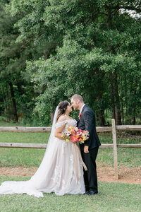 Luxury Atlanta bride holding colorful bouquet  kissing her groom