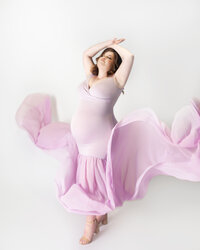 women wearing purple glam maternity gown with glam makeup during maternity photoshoot in Franklin Tennessee photography studio