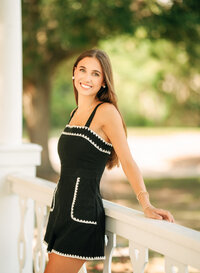 Senior portrait in downtown Foley, Alabama — leaning on a railing beneath a white wooden
gazebo.