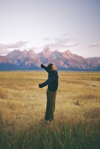 Sam Dykstra, gay photographer, posing in front of mountains.