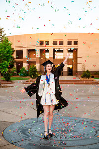 MTSU senior wearing all her graduation attire and popping confetti on the campus seal